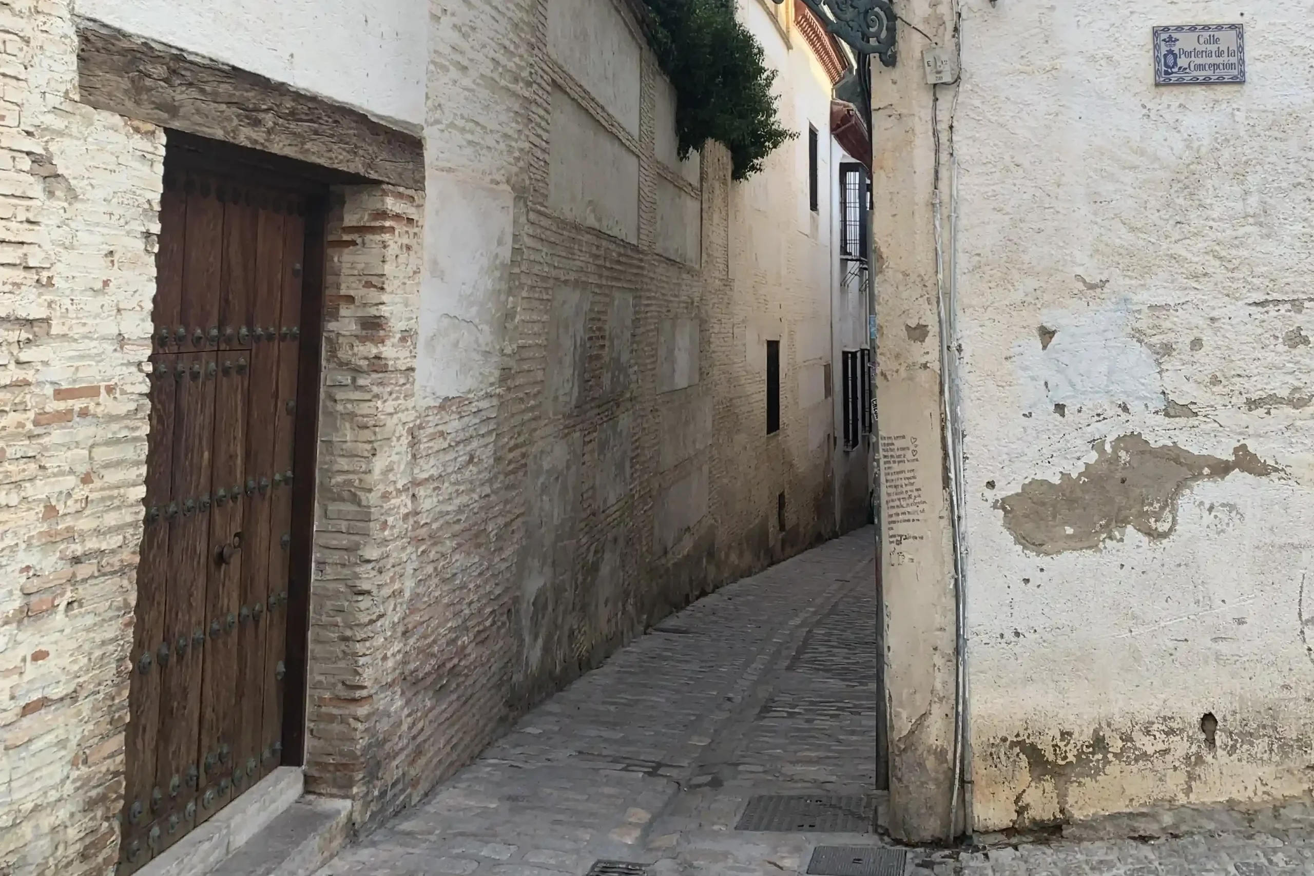 Vicolo stretto dell’Albaicín a Granada tra mura antiche e case bianche