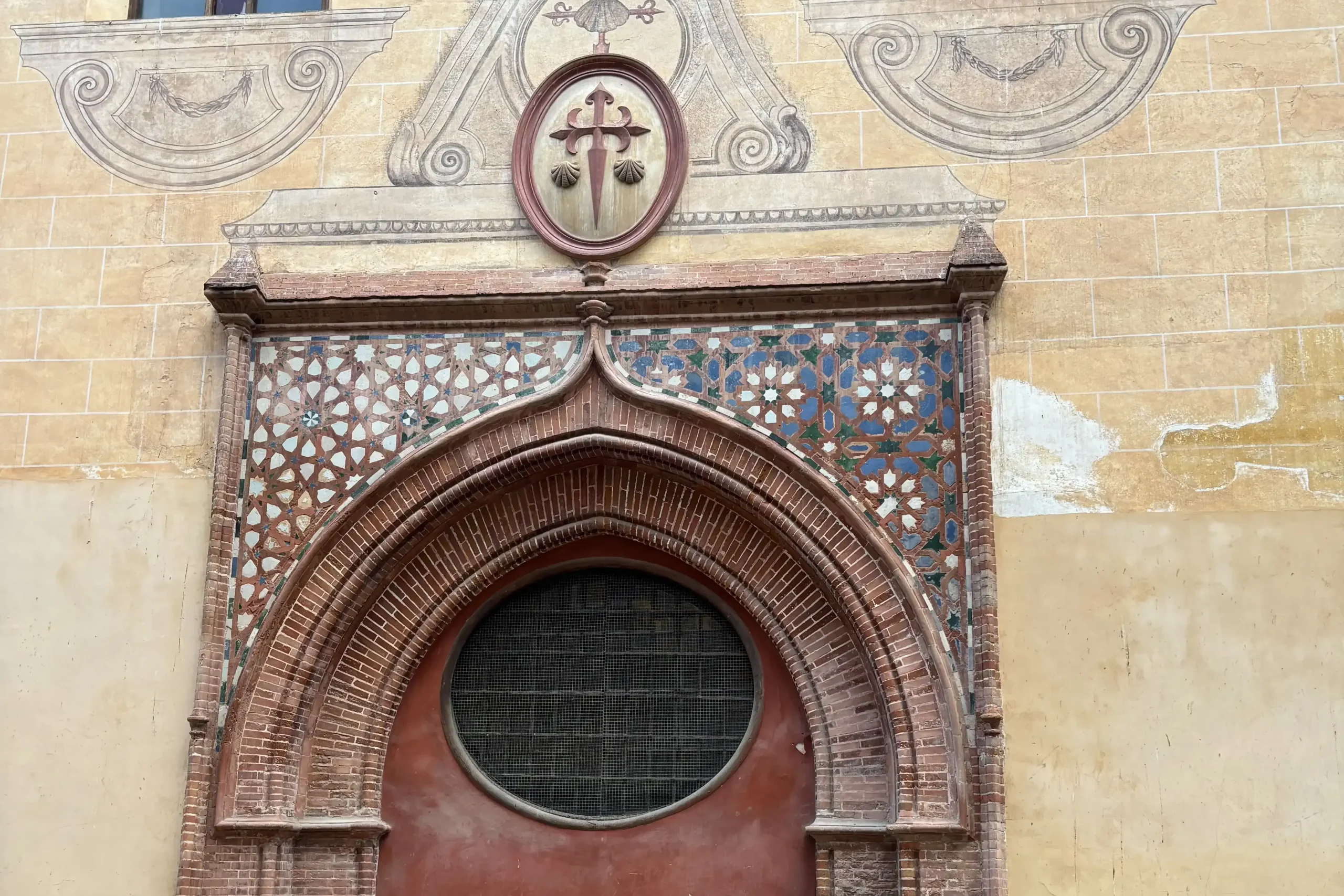 Portale della Chiesa di Santiago Apóstol a Málaga, ingresso storico con arco in mattoni e decorazioni mudéjar