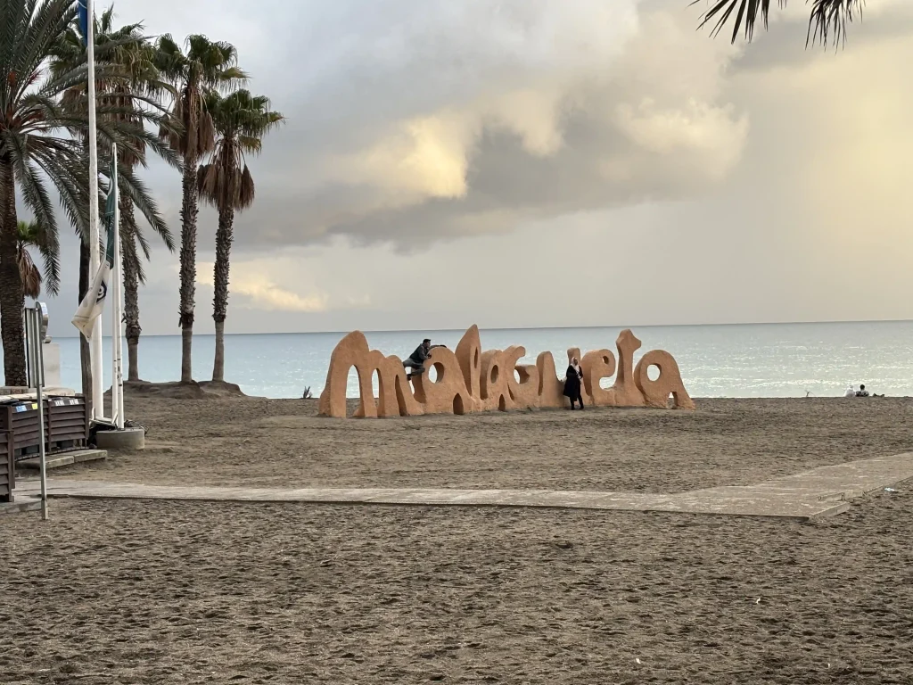 Grandi lettere Malagueta sulla sabbia della Playa de la Malagueta a Málaga vicino al paseo marítimo