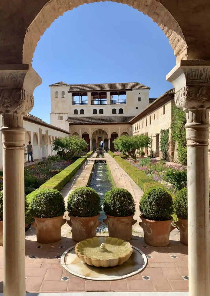 Il Patio de la acequia nei giardini del Generalife all’Alhambra di Granada con canale d’acqua centrale e archi in primo piano