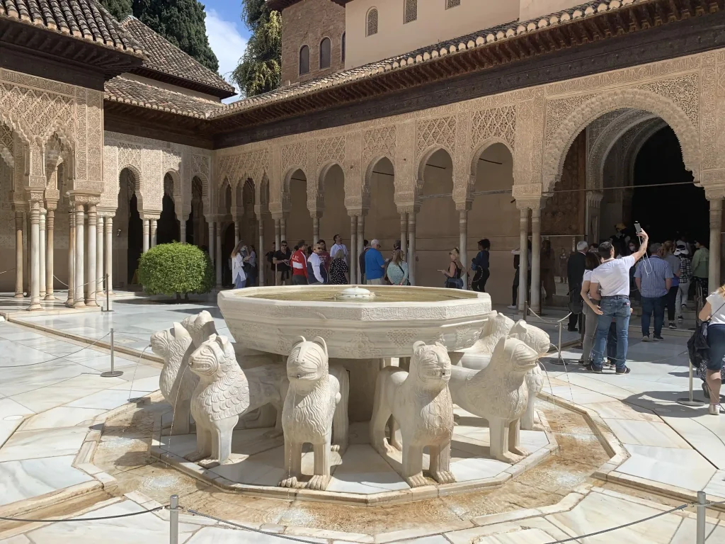 Fontana dei Leoni nel Patio de los Leones dell’Alhambra di Granada con il colonnato nasride sullo sfondo