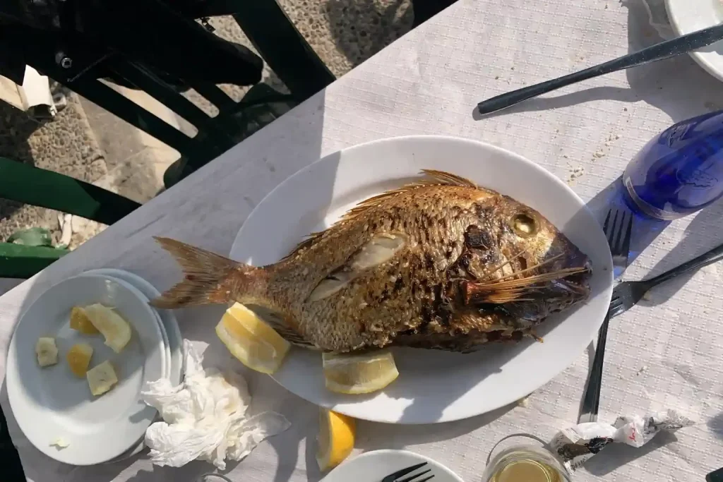 Mangiare a Málaga Pargo alla griglia servito in un chiringuito di El Palo con limone