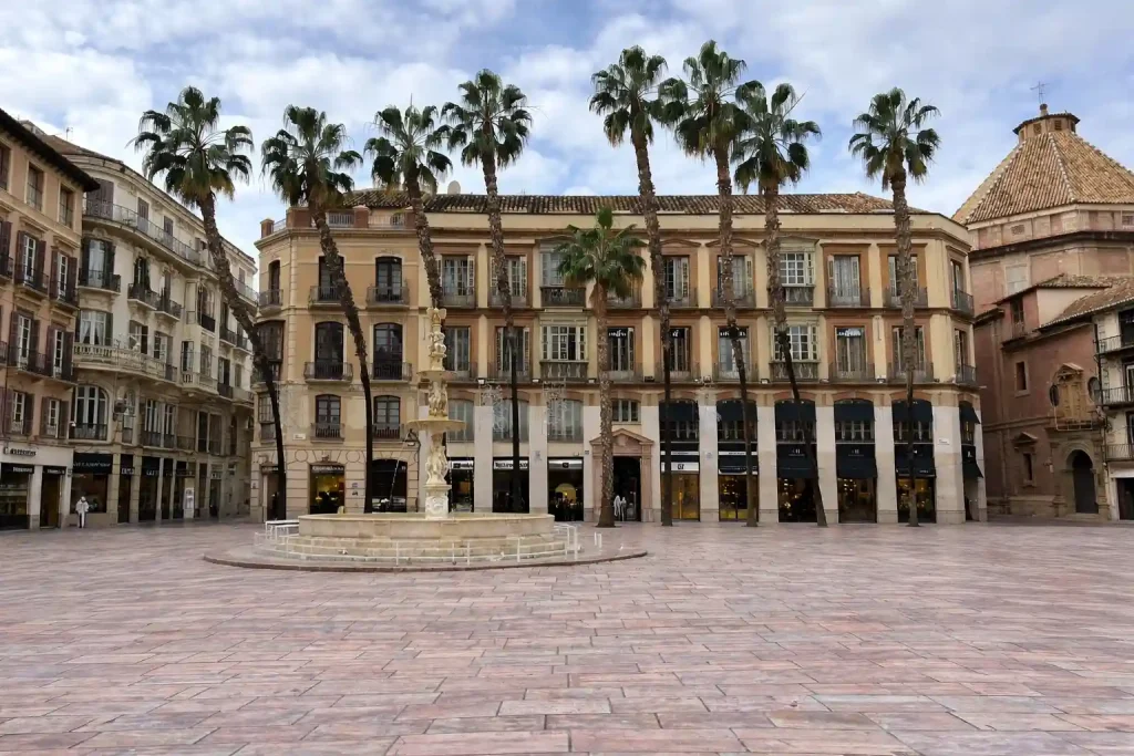 Plaza de la Constitución a Málaga con fontana e palme, una delle principali cose da vedere nel centro storico