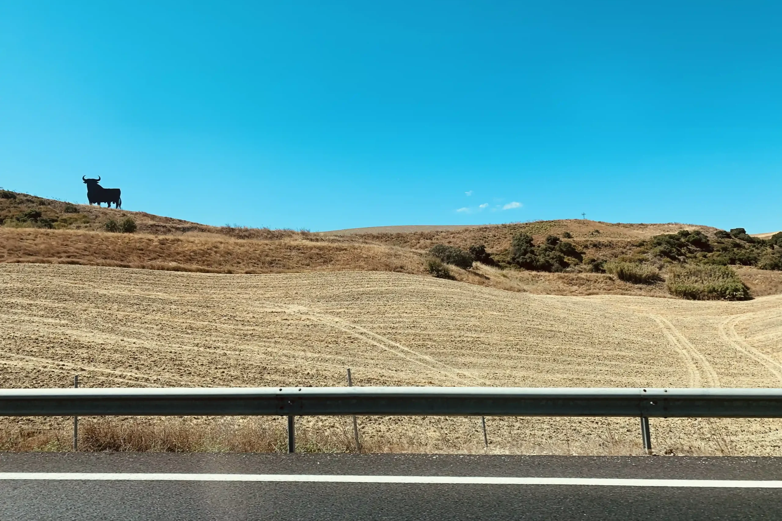 Paesaggio tipico dell’Andalusia visto dall’autostrada con il toro nero Osborne sulla collina
