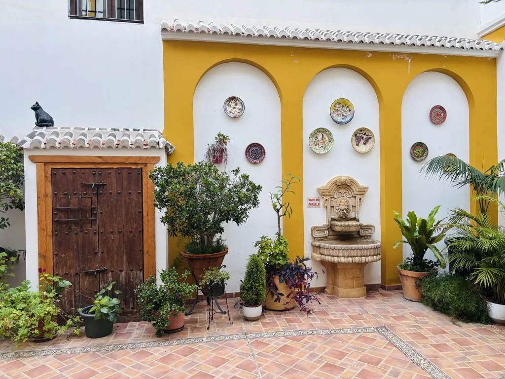 Patio andaluso nel centro storico di Nerja con fontana, piante e piatti decorativi