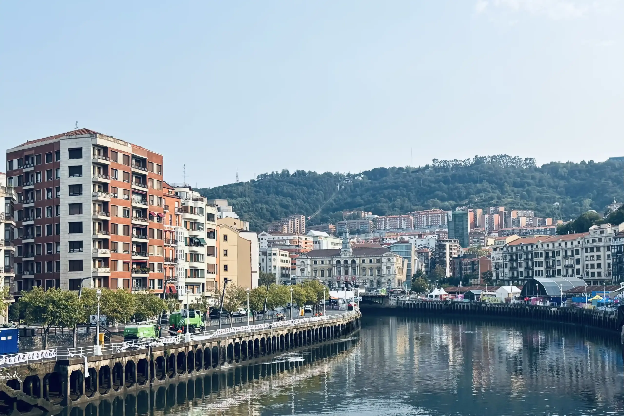 Vista della Ría del Nervión a Bilbao con palazzi storici e colline verdi sullo sfondo