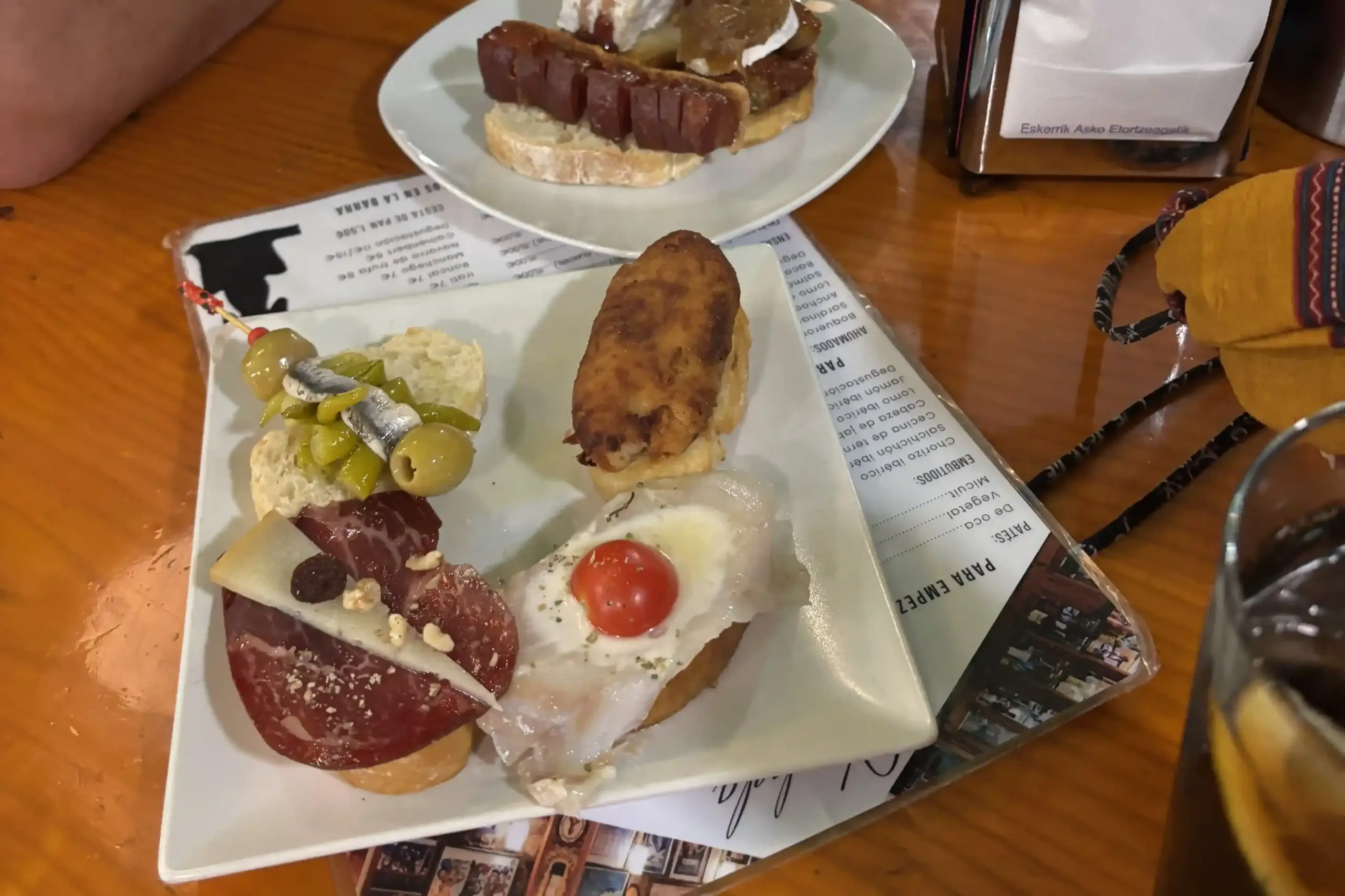 Piatto di pintxos tipici a Bilbao con gilda, croqueta, salame e uovo su pane, al Cafè Bar Bilbao