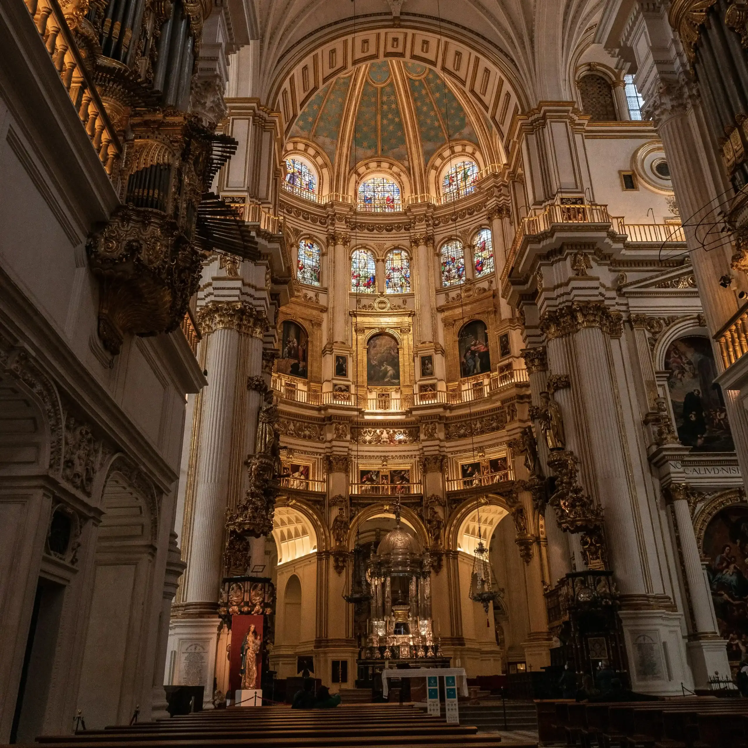 Interno della Catedral de Granada con grande cupola, colonne monumentali e altare centrale