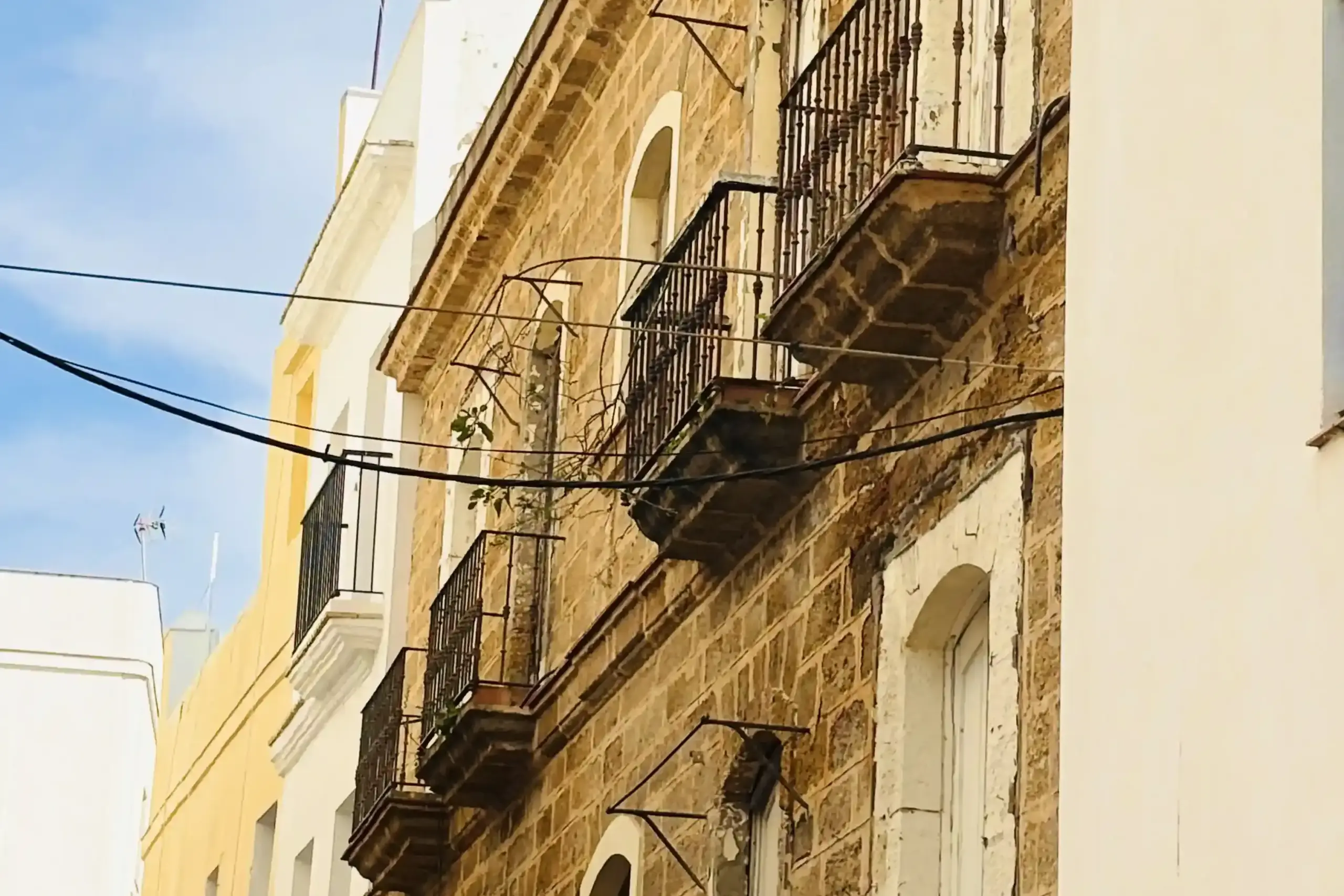 Balconi in ferro battuto nel Barrio del Pópulo a Cadice con facciata in pietra dorata
