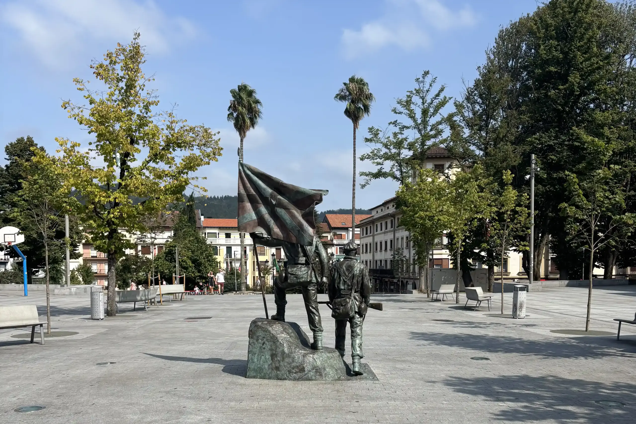 Monumento al Gudari a Gernika con due figure bronzee e bandiera basca, nei Paesi Baschi