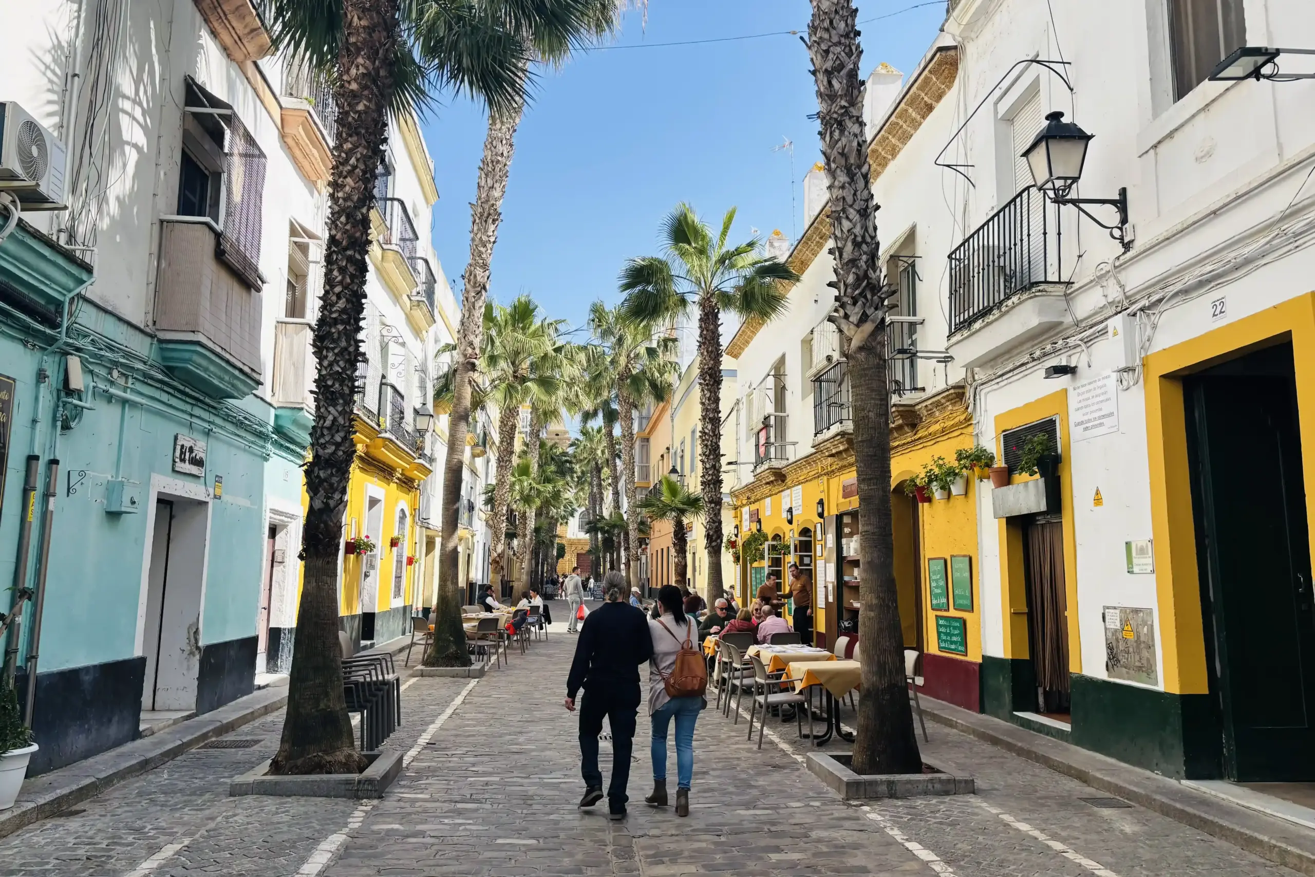 Vicolo del quartiere La Viña a Cádiz con tavolini all’aperto e palazzi storici andalusi