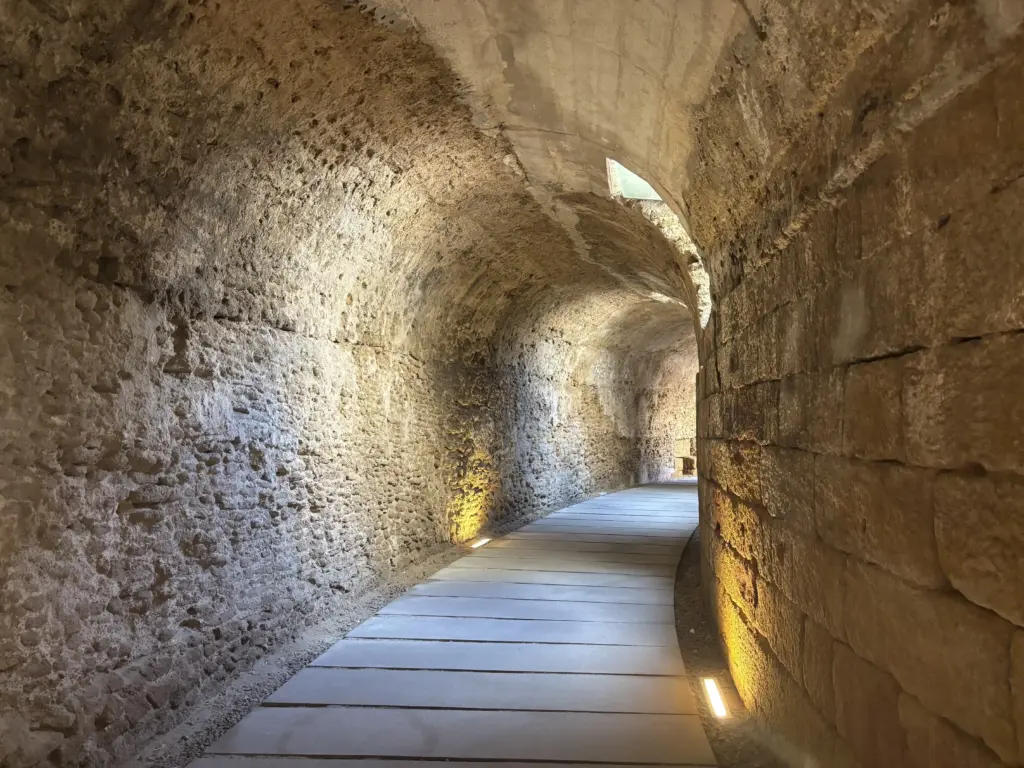 Galleria sotterranea del Teatro Romano di Cádiz con pareti in pietra e illuminazione soffusa