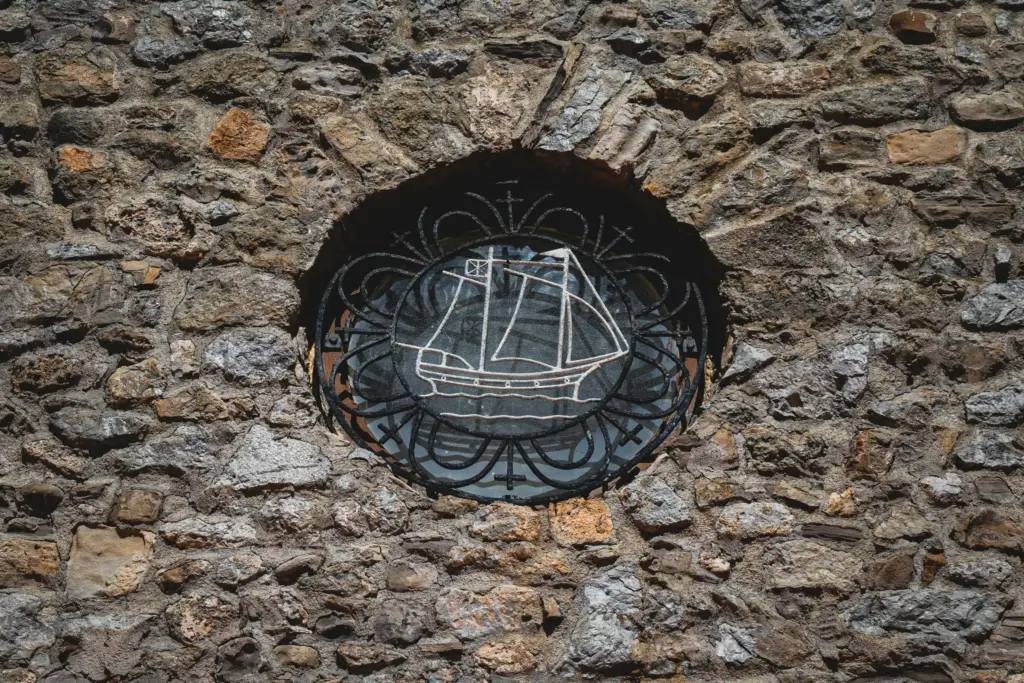 Ex voto con disegno di una nave a vela incastonata in un muro di pietra a San Juan de Gaztelugatxe