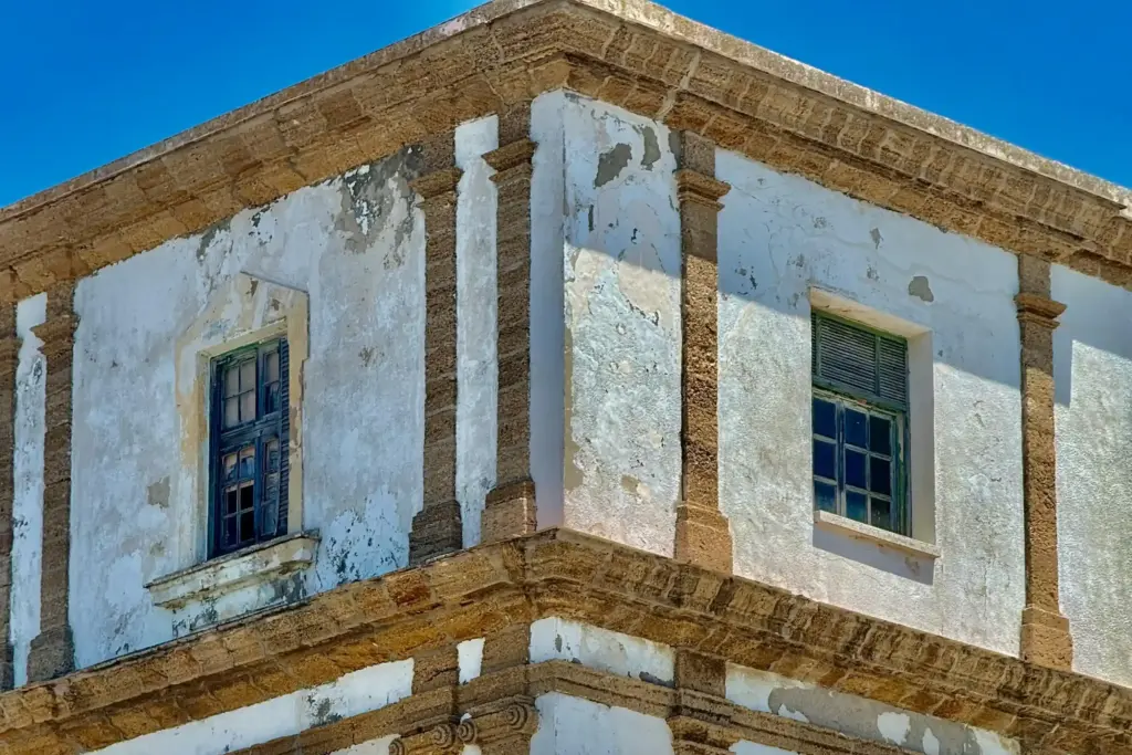 Tipico palazzo settecentesco nel centro storico di Cádiz, con facciata bianca e dettagli in pietra dorata