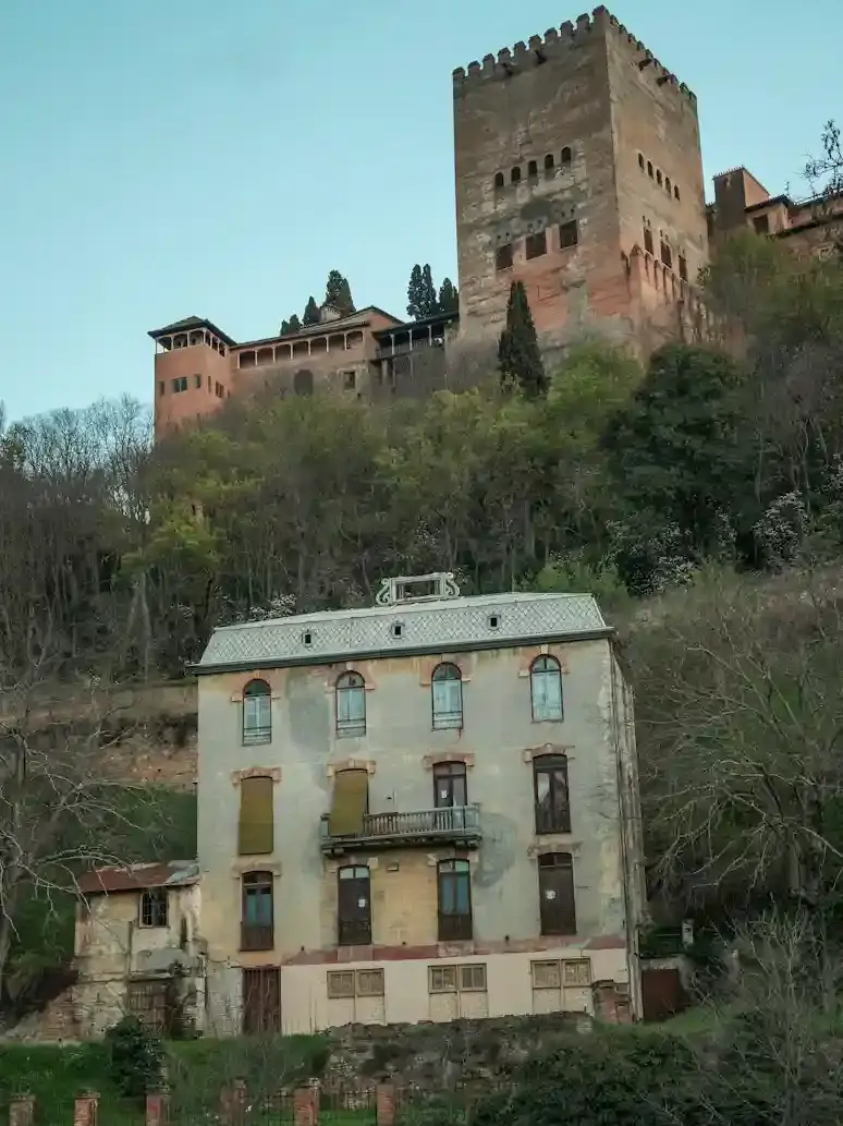 Torre dell’Alhambra che domina le case storiche lungo il fiume Darro e la cuesta a Granada