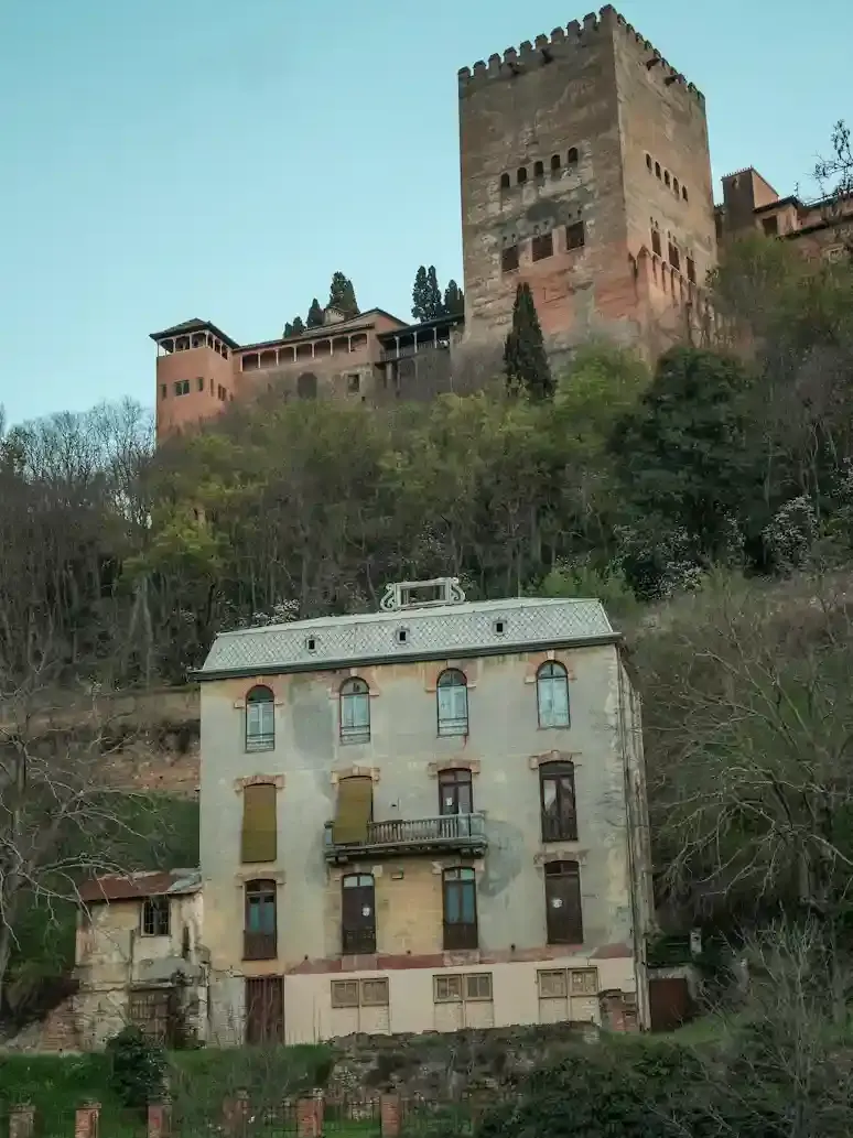 Torre dell’Alhambra che domina le case storiche lungo il fiume Darro e la cuesta a Granada