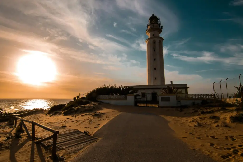 Faro de Trafalgar al tramonto tra dune e oceano sulla Costa de la Luz in Andalusia