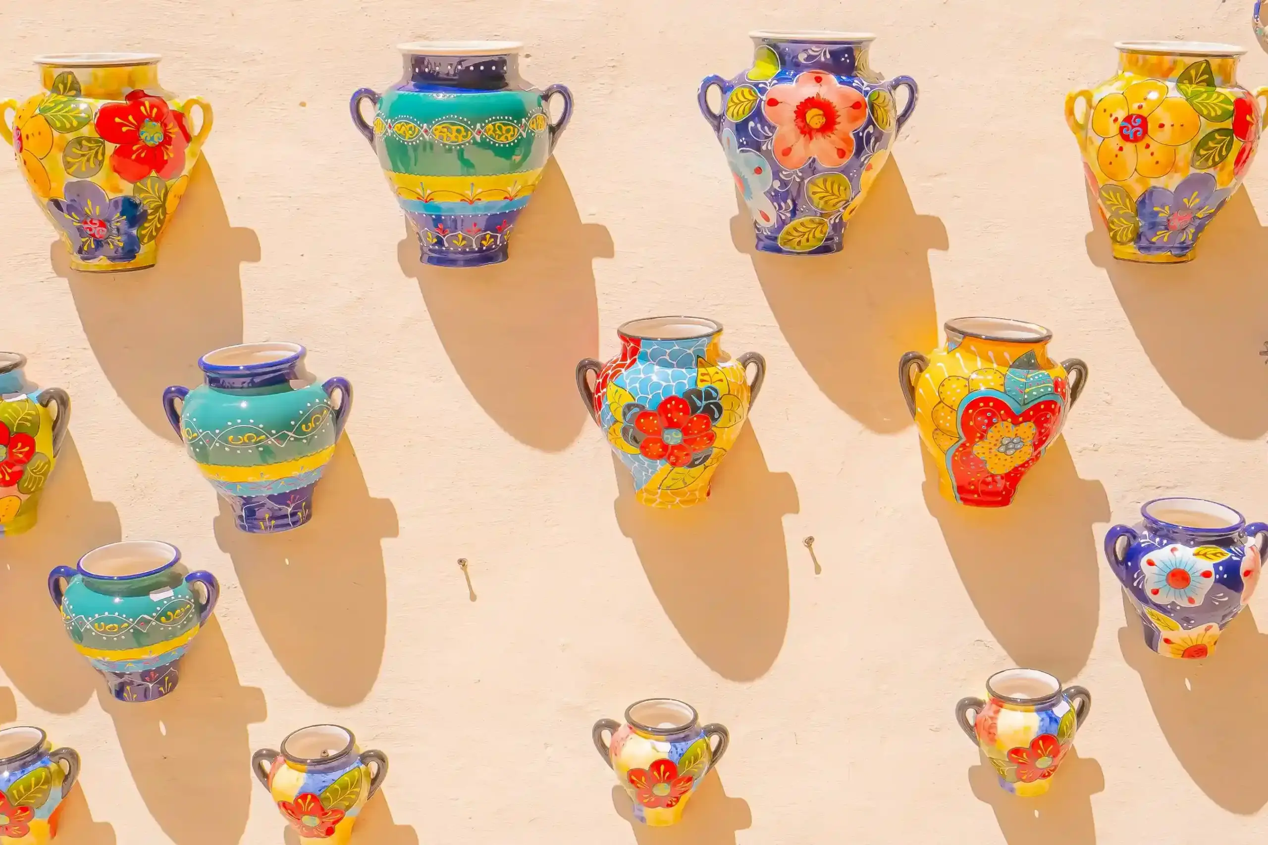 Vasi in ceramica andalusa colorata appesi su una parete a Nerja