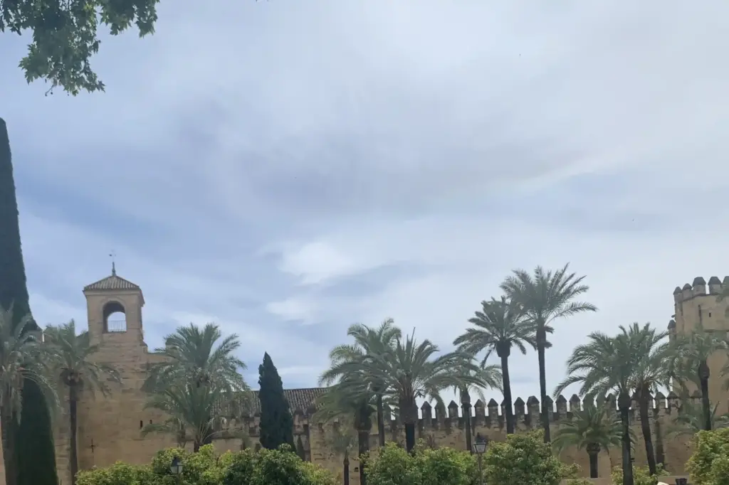 Mura dell’Alcázar de los Reyes Cristianos di Córdoba circondate da palme e cipressi