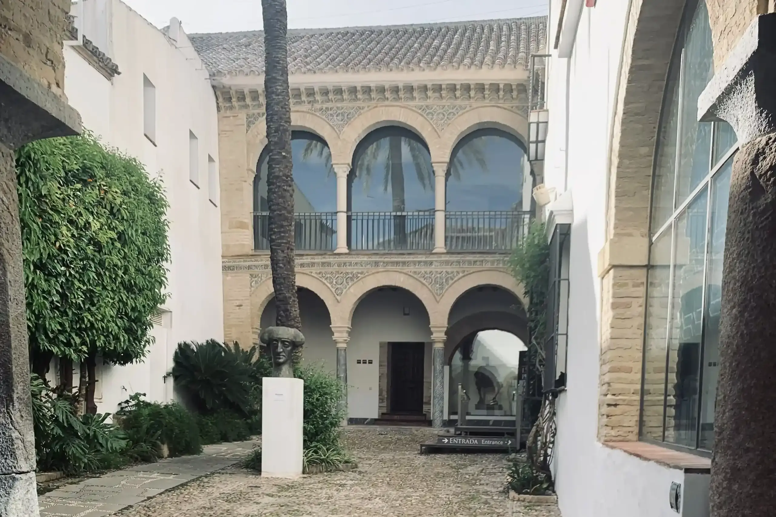 Cortile d’ingresso del Museo Taurino di Córdoba con archi mudéjar e pavimentazione in ciottoli
