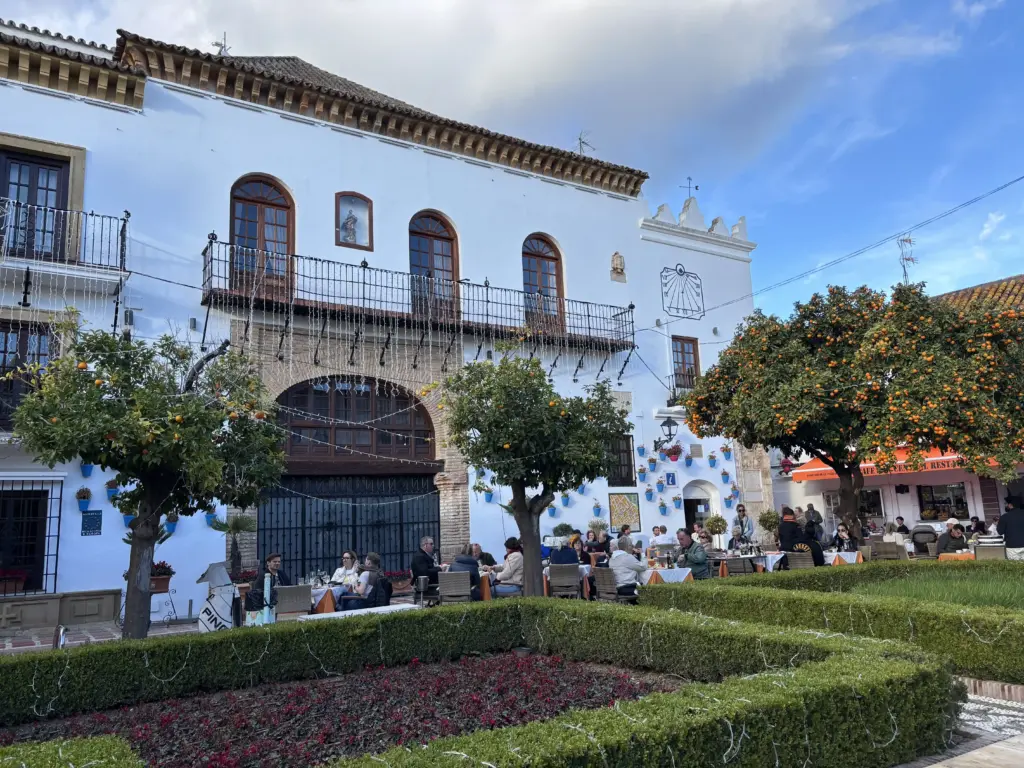 Plaza de los Naranjos a Marbella con alberi di arancio, edifici storici e tavolini all'aperto