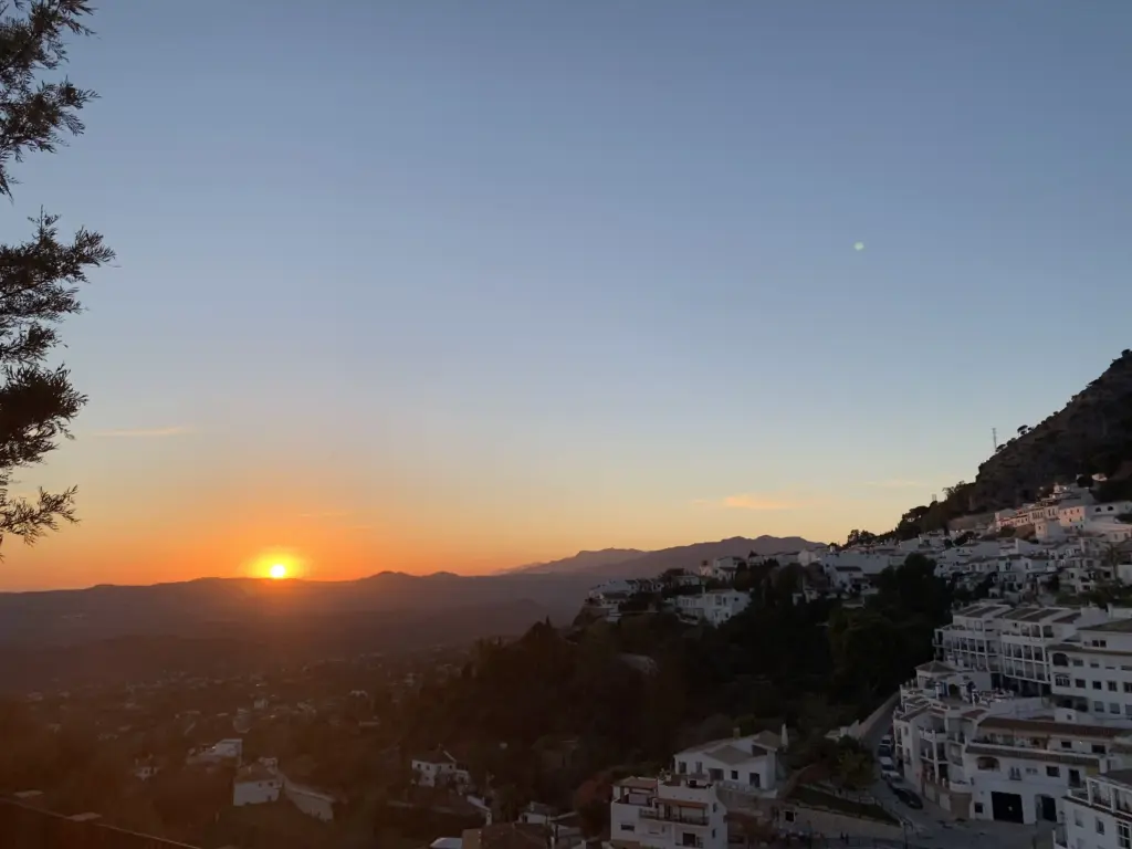 Tramonto panoramico su Casares con case bianche e montagne dell'Andalusia sullo sfondo