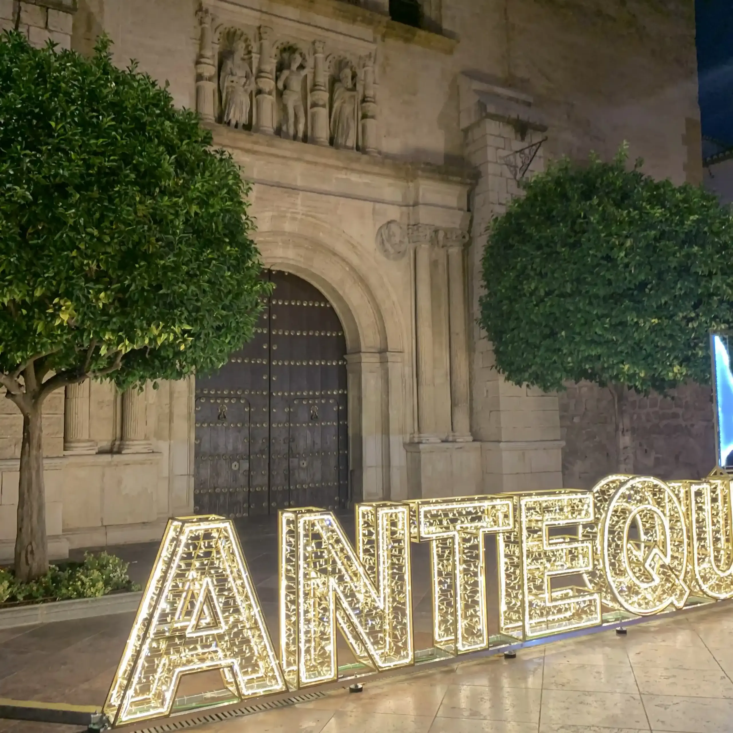 Scritta luminosa Antequera davanti alla Real Colegiata di Santa María la Mayor di notte