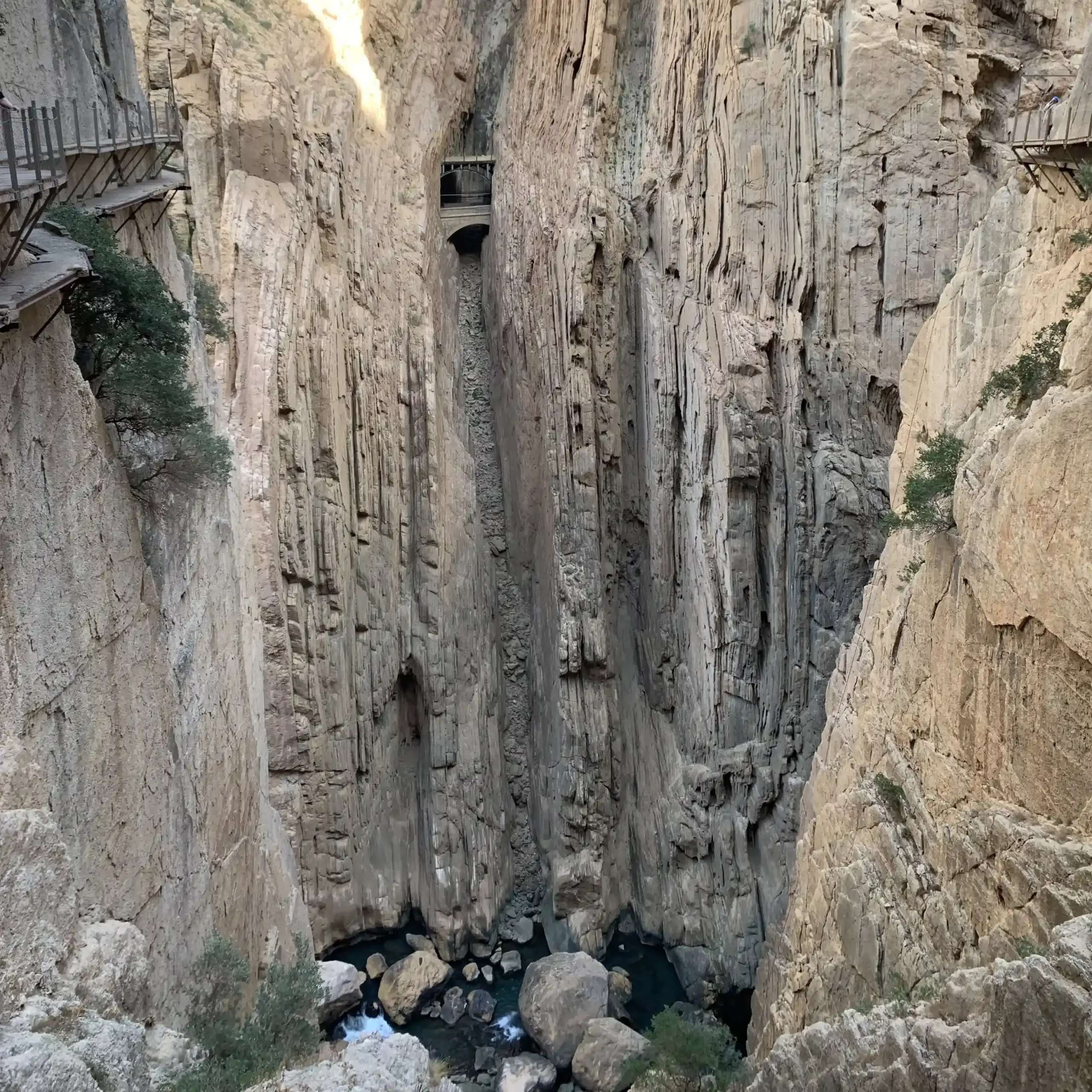 Vista del tratto più stretto del Desfiladero de los Gaitanes lungo il Caminito del Rey, con pareti rocciose verticali e il fiume sul fondo della gola.