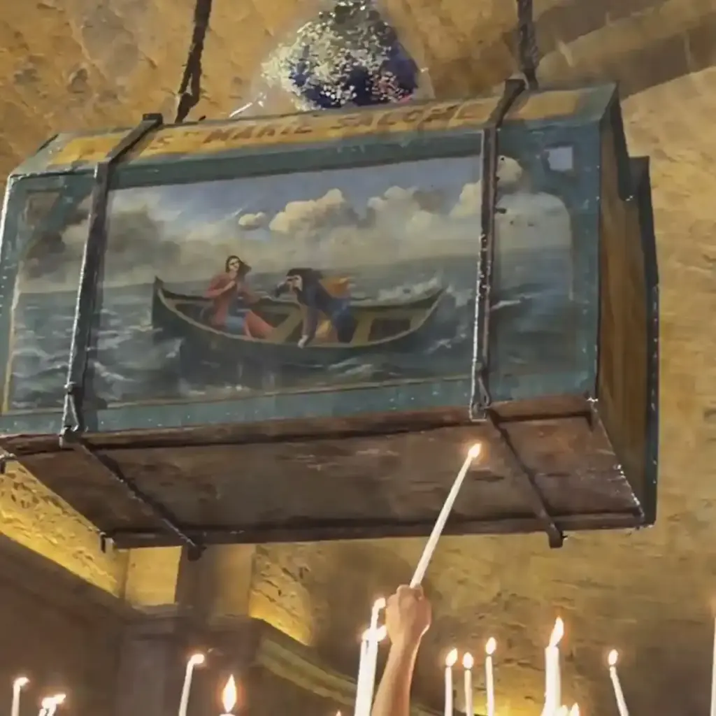 Reliquiario decorato all’interno della chiesa di Saintes-Maries-de-la-Mer, con candele accese e scena delle sante sulla barca