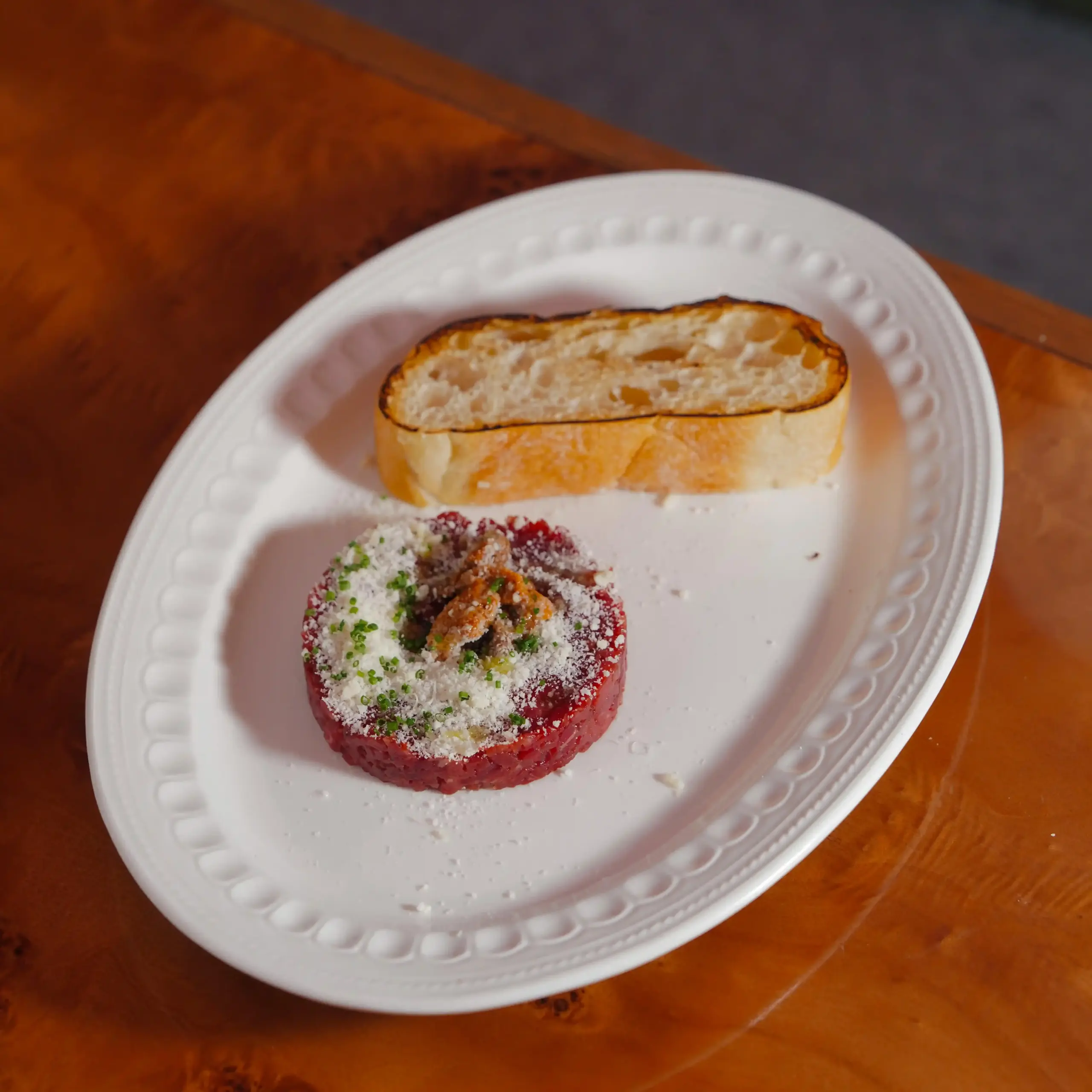 Pintxo gourmet scomposto su piatto bianco in un Ristorante Michelin a San Sebastián, con pane e guarnizioni