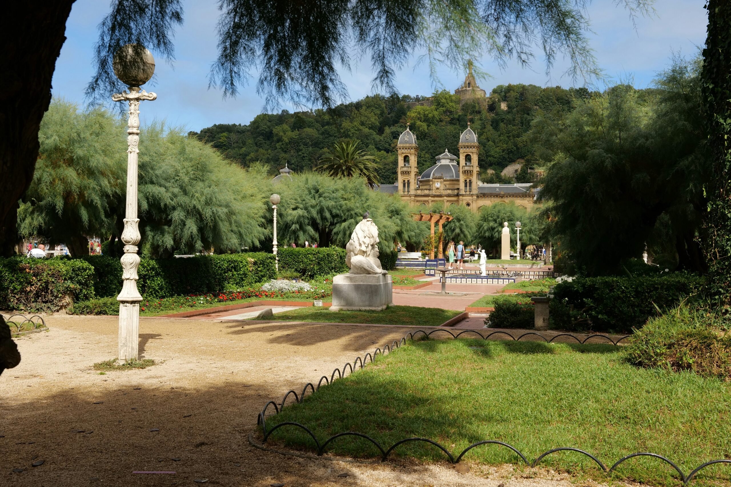 Giardini di Alderdi Eder con aiuole, alberi, lampioni e Municipio di San Sebastián sullo sfondo
