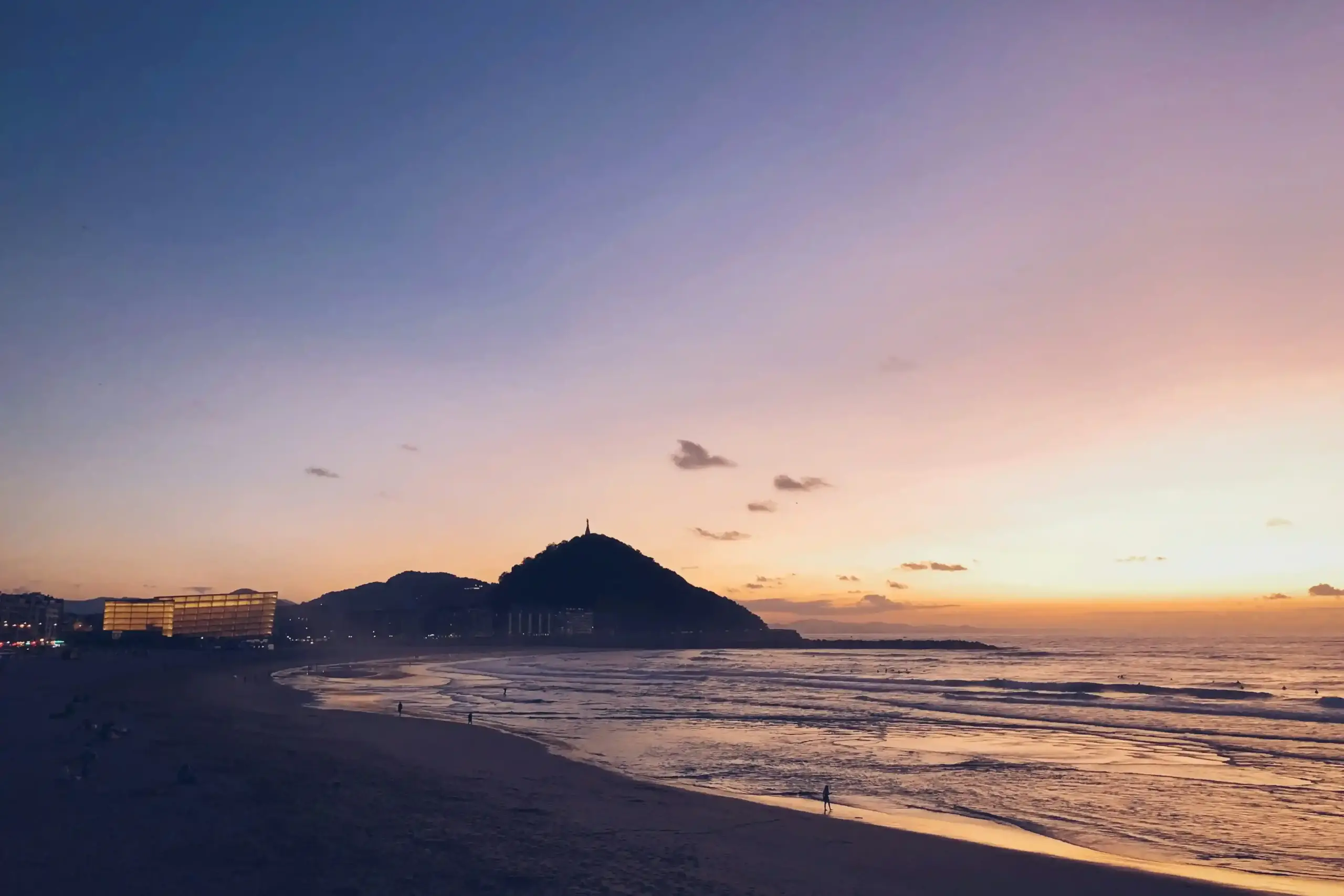 Tramonto sulla spiaggia della Zurriola a San Sebastián con il Monte Ulía sullo sfondo