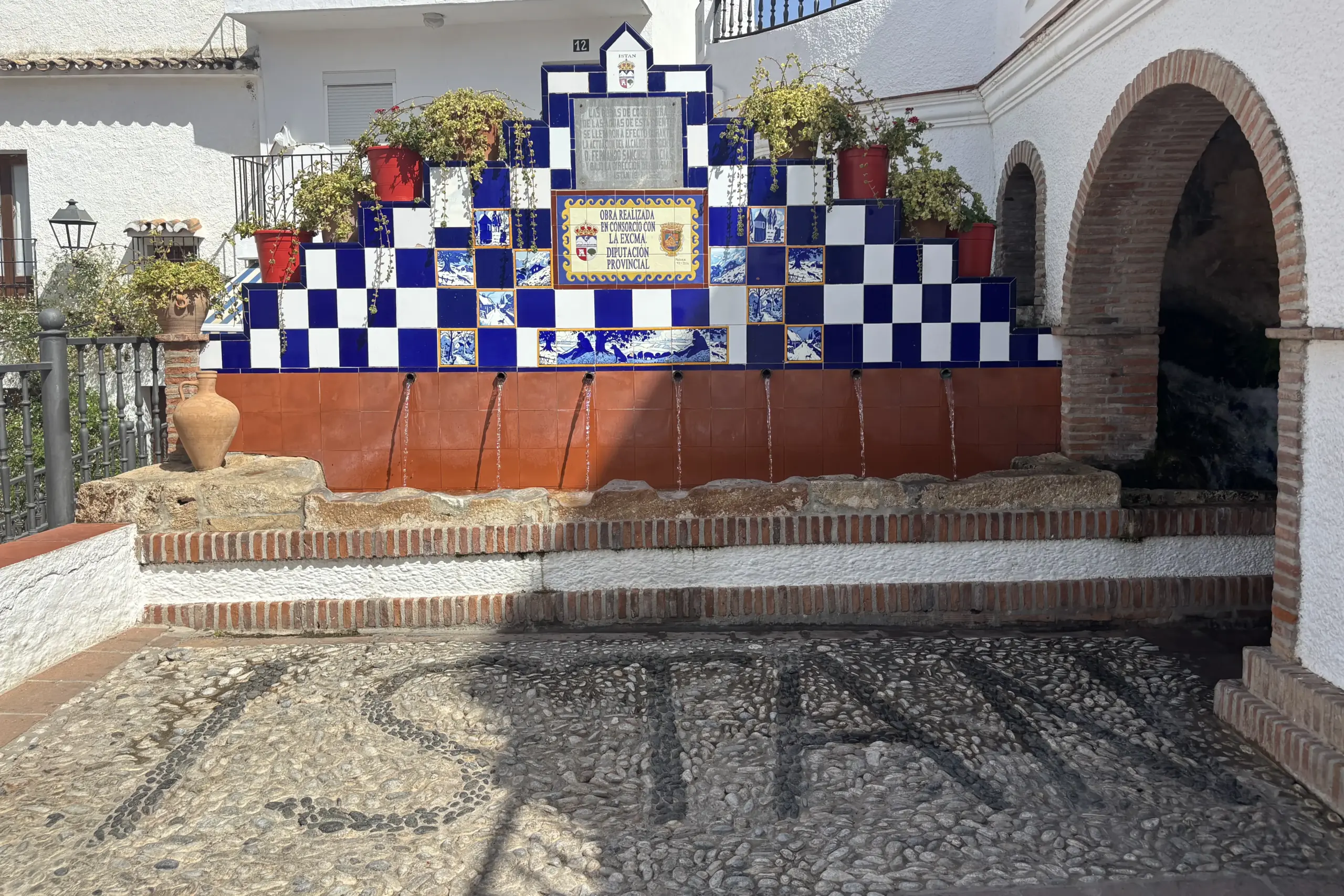 Fontana decorata con piastrelle bianche e blu nel centro di Istán