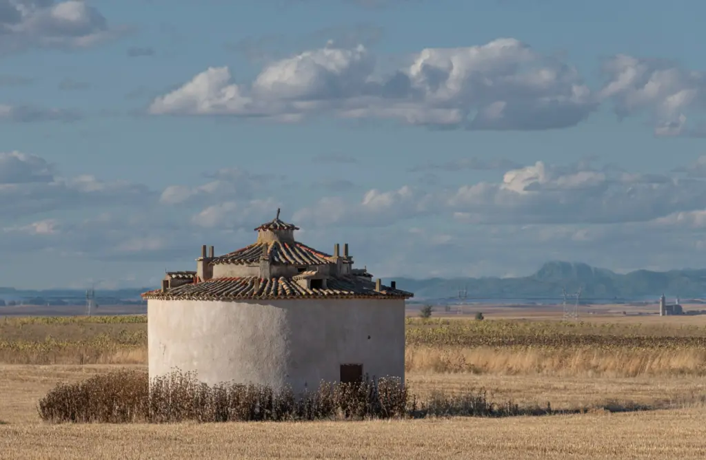 Paesaggio rurale della Mancha con campi coltivati e costruzione tradizionale