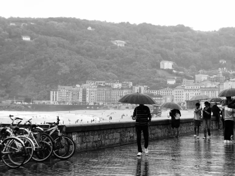 Persone con l’ombrello sul lungomare di San Sebastián durante una giornata di pioggia
